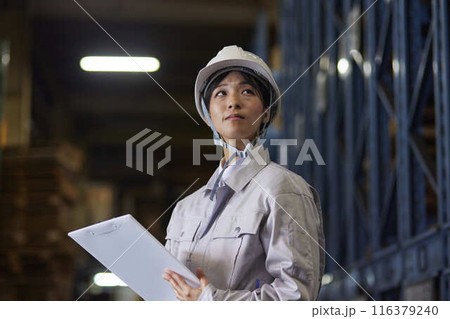 工場内で点検を行う作業着を着た女性 116379240