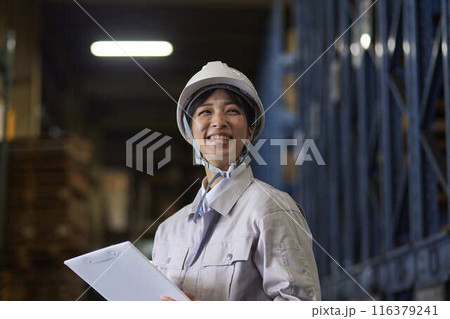 工場内で点検を行う作業着を着た女性 116379241