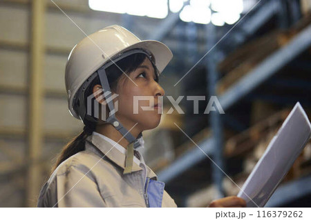 工場内を目視点検する女性作業員の横顔 工場内を目視点検する女性作業員の横顔 116379262