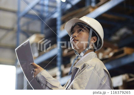 工場設備を見上げて点検する日本人女性エンジニア 116379265
