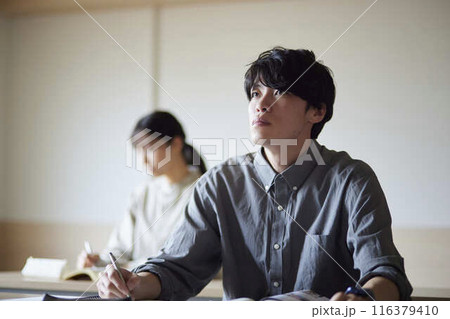 大学の講義を受けながら前を見る男子学生 大学の講義を受けながら前を見る男子学生 116379410