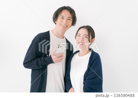 スマホを持つ笑顔の男女 スマホを持つ笑顔の男女 116380488