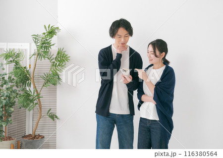 スマホを見て笑う男女 116380564