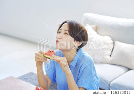 自宅でスイカを食べる女性 116383013