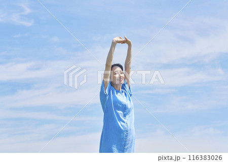 屋外で伸びをする女性 116383026