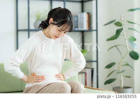お腹は痛い若い女性 116383253