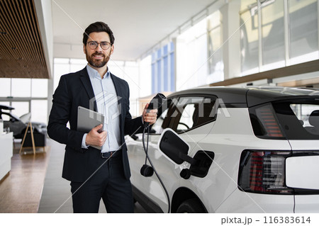 Dealer sells electric car in modern vehicle dealership 116383614