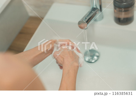 自宅の洗面台で手を洗う50代女性の手元 116385631