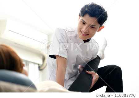 女性患者にマッサージ整体の施術をする男性 116385776
