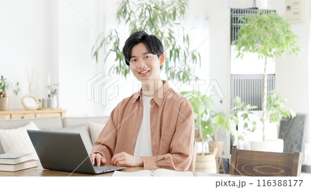 自宅でノートパソコンを使う男性	 116388177