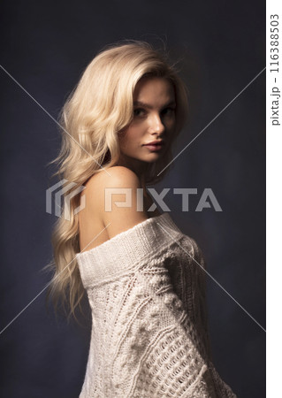 Portrait of a beautiful young blonde on a dark background, a photo of a young woman with long hair 116388503