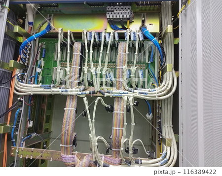 Telephony cables and wires connected to connectors and motherboards fixed on slats and secured with nylon white clamps 116389422