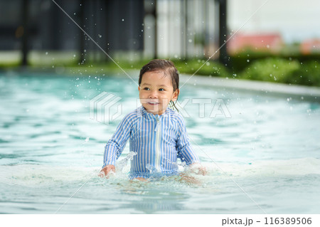 happy toddler baby playing water splashing in swimming pool 116389506