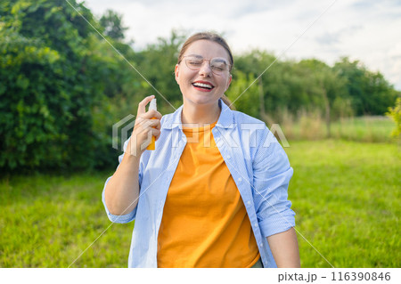 Woman applying insect repellent against mosquito, summertime health care, protection and people concept Woman applying insect repellent against mosquito, summertime health care, protection and people concept 116390846