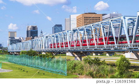 川崎の都市風景　多摩川を渡る京急線の電車と川崎駅前のビル群【神奈川県・川崎市】 116391568