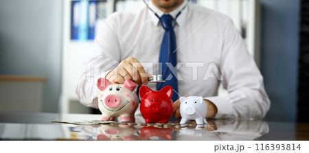 Funny businessman listen three piggybanks for cash 116393814