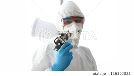 Workman hold in arm airbrush gun wearing protective suit Workman hold in arm airbrush gun wearing protective suit 116393821