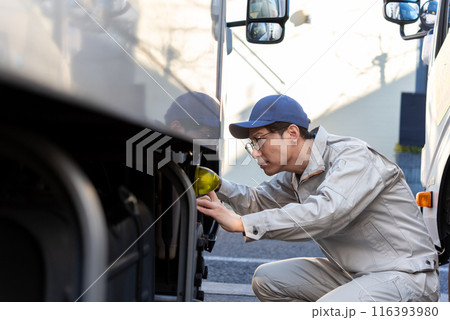 タイヤの点検をする男性トラックドライバー 116393980