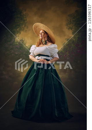 Timeless Victories Elegance. Portrait of medieval loyal person, elegant young woman in velvet green dress, white blouse and hat posing against vintage background Timeless Victories Elegance. Portrait of medieval loyal person, elegant young woman in velvet green dress, white blouse and hat posing against vintage background 116396317