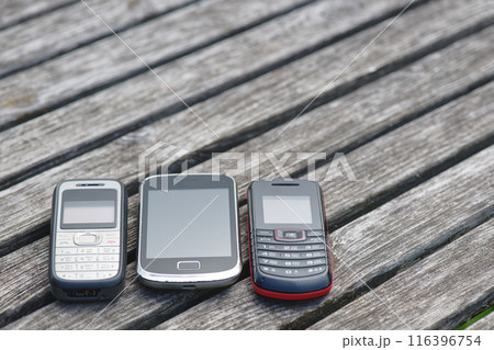 Old cell phones on wooden table Old cell phones on wooden table 116396754
