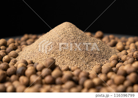 Ground black pepper and peppercorns close-up. Ground black pepper and peppercorns close-up. 116396799