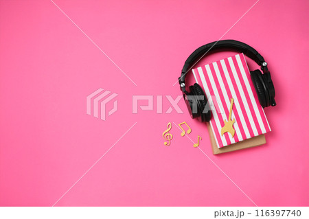Books with modern headphones, on a pink background. 116397740