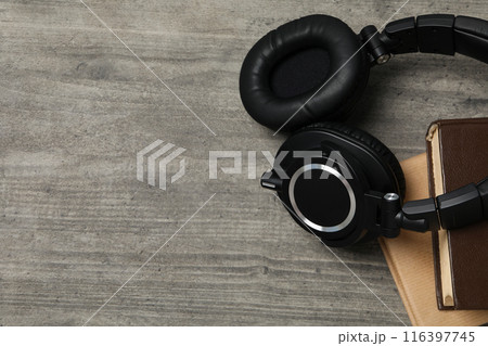 Books with modern headphones, on a gray background. 116397745