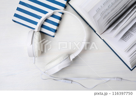 Books with modern headphones, on a light background. 116397750