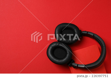 Books with modern headphones, on a red background. 116397751