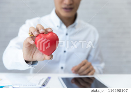 Doctor hands hold a red heart over desk. Concept of health care and medical. Doctor hands hold a red heart over desk. Concept of health care and medical. 116398107