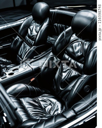 The image showcases the luxurious comfort of plush black leather car seats with a detailed focus on the stitching and design. The high-quality materials used reflect sense of exclusivity and comfort. 116398748