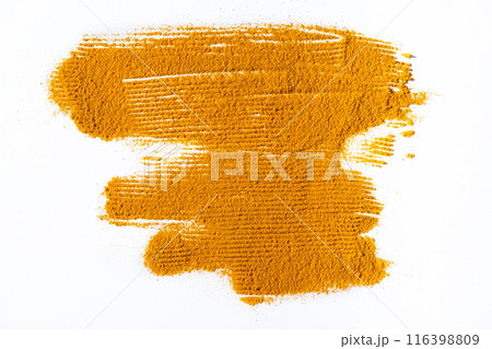 A smear of turmeric on a white background, top view A smear of turmeric on a white background, top view 116398809
