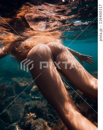 Ideal body of slim woman with red hairs underwater in blue sea Ideal body of slim woman with red hairs underwater in blue sea 116400317