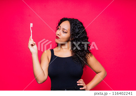Pretty african lady with beautiful smile holding toothbrush and taking care of her teeth health 116402241