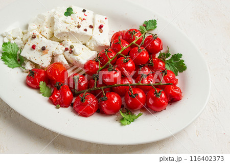 baked cherry tomatoes , with cheese, and spices, on a white plate, homemade, no people, baked cherry tomatoes , with cheese, and spices, on a white plate, homemade, no people, 116402373