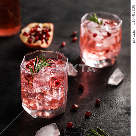 Healthy pomegranate juice with ice in a glass on a dark vintage background close up  116403839