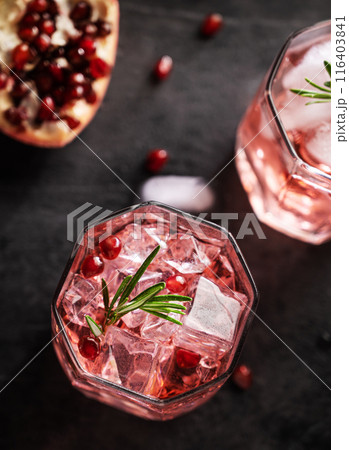 Healthy pomegranate juice with ice in a glass on a dark vintage background close up  116403841