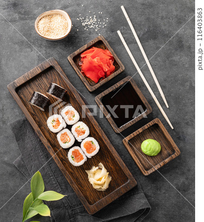 Set of rolls with raw salmon, rice and nori on a wooden board. Japanese sushi food concept Set of rolls with raw salmon, rice and nori on a wooden board. Japanese sushi food concept 116403863