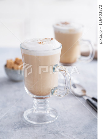Two glasses of fragrant cappuccino coffee with cinnamon on a blue table  116403872