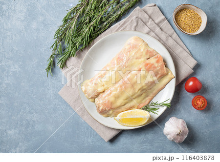 Raw fillet salmon marinade with spices and mustard sauce  on a plate on a blue background  116403878