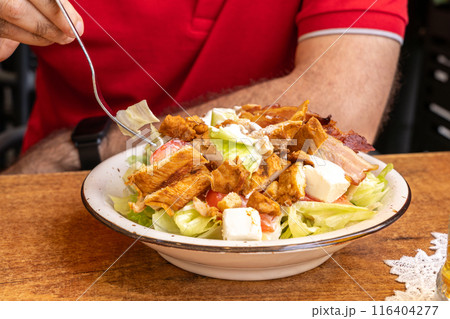 Polish Caesar salad with chicken, bacon and vegetables, high-calorie meat salad with fresh vegetables 116404277