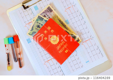 Expensive medicine, healthcare at Japan with stethoscope on heart electrocardiogram ECG, Japanese yen, Japanese passport 116404289