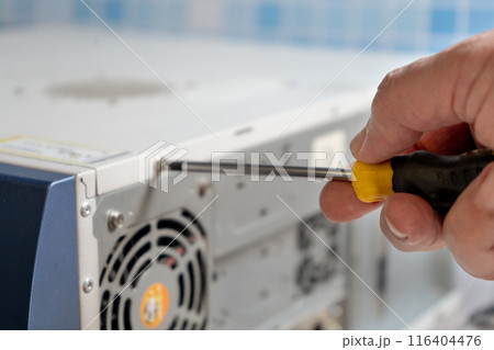technician adjusting the screw on a cabinet lid. 116404476