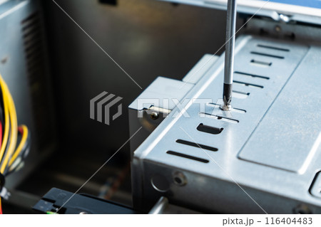 technician adjusting the screw on a cabinet lid. 116404483