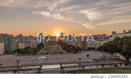 Panorama showing sunset over lawn at Alameda Dom Afonso Henriques and the Luminous Fountain aerial timelapse in Lisbon. 116405205