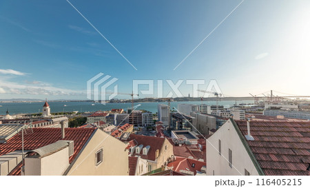 Panorama showing red roofs timelapse and 25 de Abril Bridge, Iconic suspension bridge over Tagus River in Lisbon, Portugal. Panorama showing red roofs timelapse and 25 de Abril Bridge, Iconic suspension bridge over Tagus River in Lisbon, Portugal. 116405215