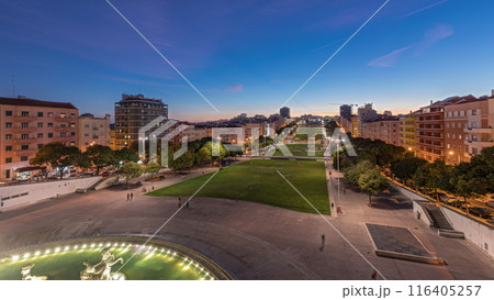 Panorama showing lawn at Alameda Dom Afonso Henriques and the Luminous Fountain aerial day to night timelapse in Lisbon. 116405257