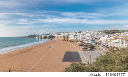 Wide sandy beach and Atlantic ocean in city of Albufeira timelapse. Algarve, Portugal 116405377