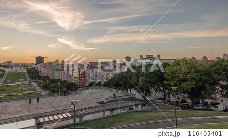 Panorama showing sunset over lawn at Alameda Dom Afonso Henriques and the Luminous Fountain aerial timelapse in Lisbon. 116405401