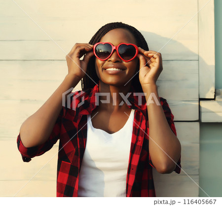 Happy young african woman in red heart shaped glasses, beautiful girl smiling in sunglasses 116405667